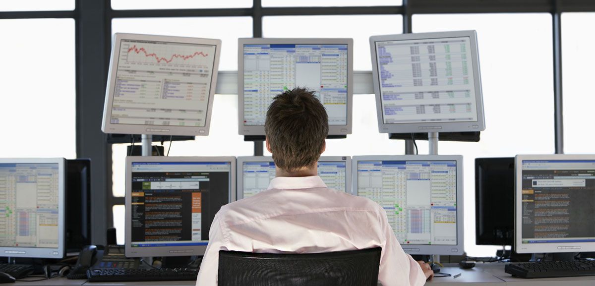 Man working security at desk with several computer monitors