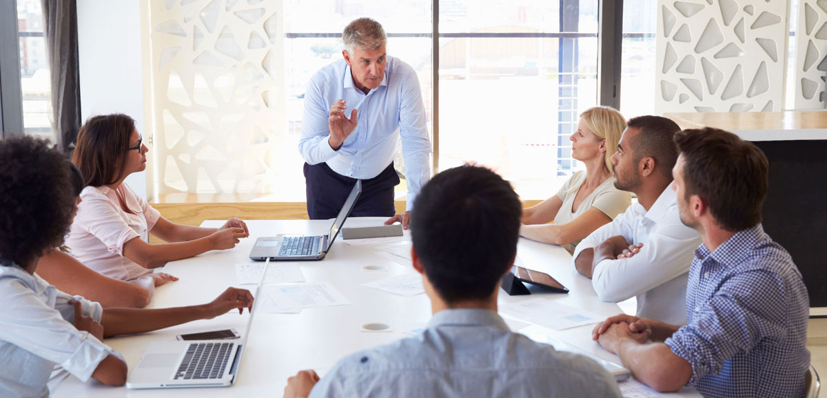 Group of people in boardroom discussing IT and their business