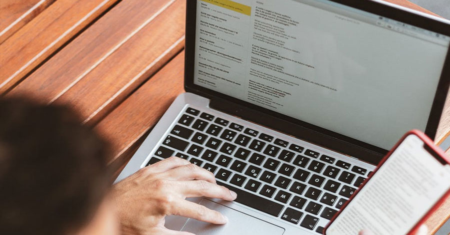 Man checking email on laptop and phone