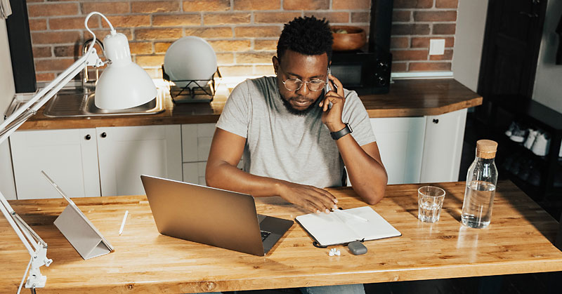 Man sitting at desk on the phone working from home