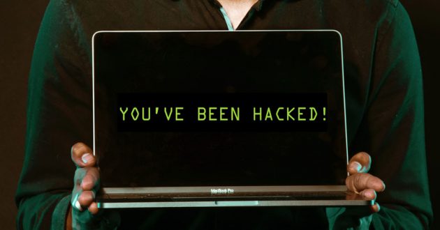 Person holding laptop with text saying youve been hacked